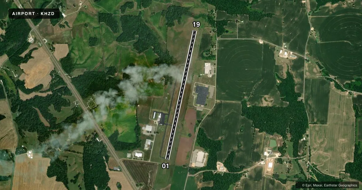 Top-down satellite sketch of KHZD SGT LEE RUSSELL CARROLL COUNTY in HUNTINGDON, TENNESSEE, showing runways 01/19 drawn to scale over Esri World Imagery