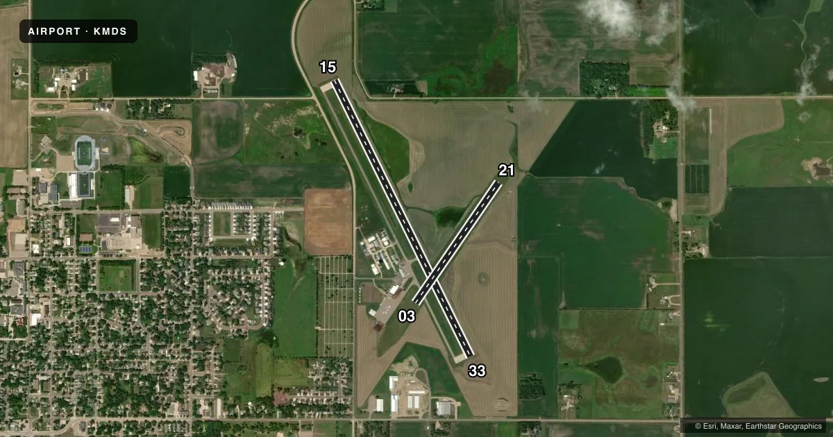 Top-down satellite sketch of KMDS MADISON MUNI in MADISON, SOUTH DAKOTA, showing runways 15/33, 03/21 drawn to scale over Esri World Imagery