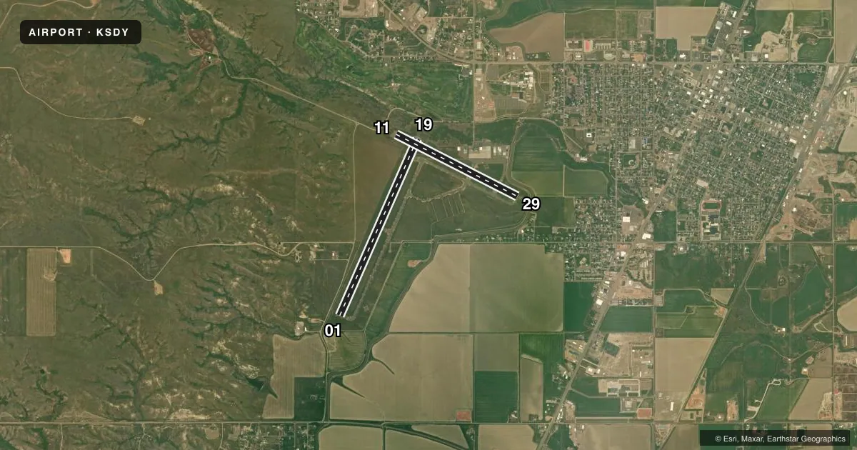 Top-down satellite sketch of KSDY SIDNEY-RICHLAND RGNL in SIDNEY, MONTANA, showing runways 01/19, 11/29 drawn to scale over Esri World Imagery
